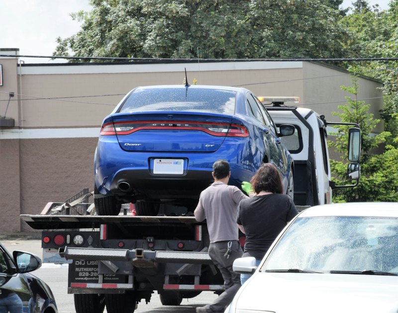 A car being loaded onto a flatbed tow truck